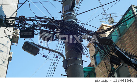 Electric pole with tangled wires in a residential area 138441646