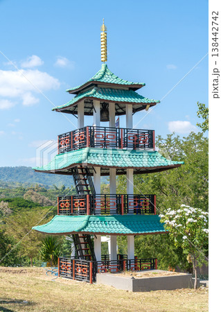 Traditional multi-tiered pavilion with green tiled roofs and white pillars set against a bright blue sky. Features decorative railings, a temple bell, and scenic mountain views in rural Thailand. Traditional multi-tiered pavilion with green tiled roofs and white pillars set against a bright blue sky. Features decorative railings, a temple bell, and scenic mountain views in rural Thailand. 138442742