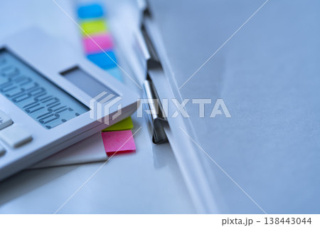 テーブルに置かれた書類と電卓 138443044