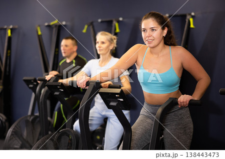 Active young woman training at elliptical machine in gym Active young woman training at elliptical machine in gym 138443473