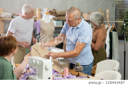 Elderly man and woman working with mannequin and making pattern in class Elderly man and woman working with mannequin and making pattern in class 138443487