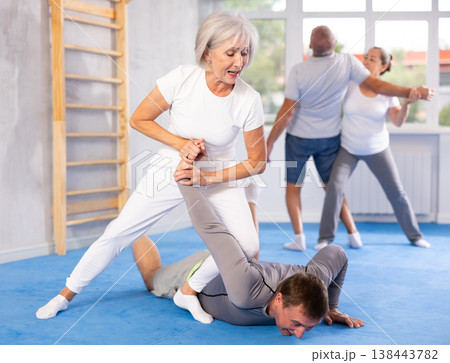 Old woman twisting her opponent's arm during self-defense classes Old woman twisting her opponent's arm during self-defense classes 138443782