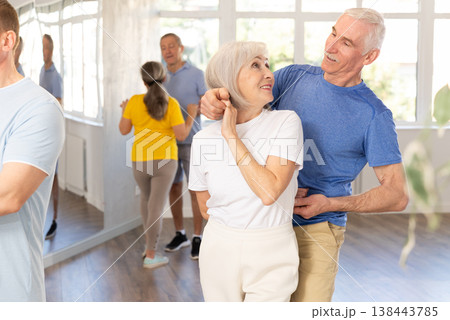 Elderly woman with male partner in latin dance class. Social dancing concept Elderly woman with male partner in latin dance class. Social dancing concept 138443785