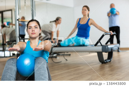 Young woman practicing pilates with ball in fitness hall 138443800