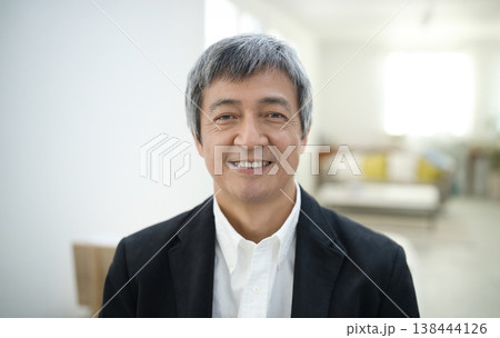 部屋でジャケットを着て微笑む60代の男性 部屋でジャケットを着て微笑む60代の男性 138444126