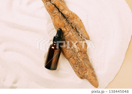 Bottle of cosmetic product serum oil dry tree podium beach white sand. Abstract podium product presentation sandy background 138445048