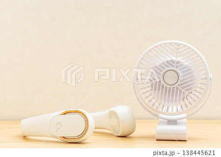 テーブルに置いた卓上ファンとネックファン テーブルに置いた卓上ファンとネックファン 138445621