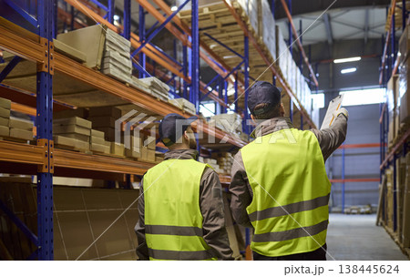 Back view of warehouse workers checking racks and planning inventory logistics Back view of warehouse workers checking racks and planning inventory logistics 138445624