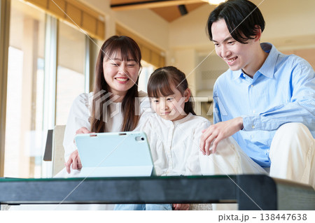 タブレットを見る家族　親子　夫婦　女の子 138447638