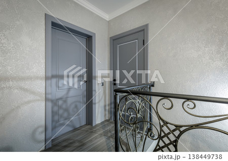 Modern Classic Hallway with Grey Doors and Wrought Iron Railings 138449738