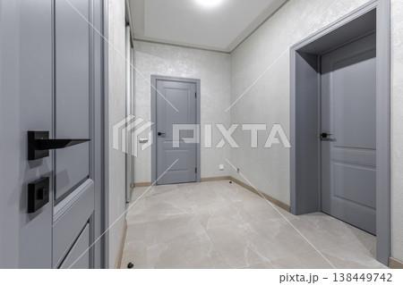 Modern Hallway Interior with Grey Doors and Stone Tile Floor 138449742
