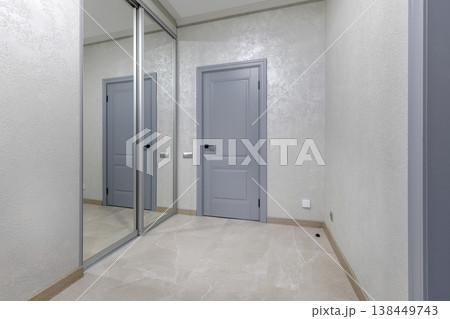 Modern Hallway Interior with Mirror Sliding Wardrobe and Grey Door 138449743