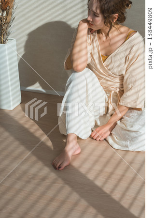 西陽の当たる窓辺にいる女性（モデル,ファッション,光,影） 138449809