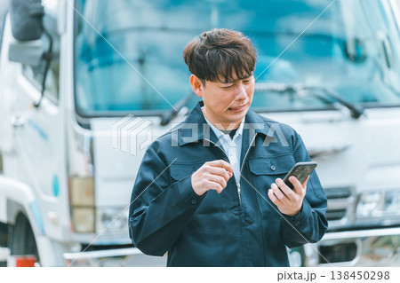 スマホ画面を見て怯えるトラックドライバー スマホ画面を見て怯えるトラックドライバー 138450298