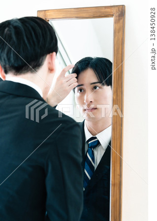 鏡の前で身だしなみを整えるスーツ姿の男性 鏡の前で身だしなみを整えるスーツ姿の男性 138450928