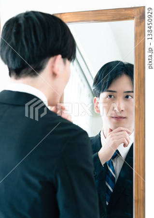 鏡の前で身だしなみを整えるスーツ姿の男性 138450929