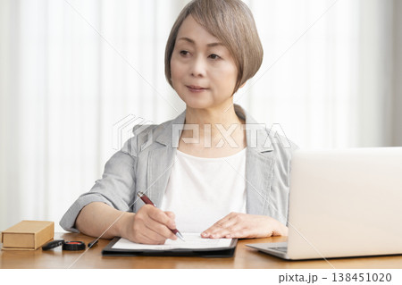 契約書に署名捺印するシニア女性 138451020