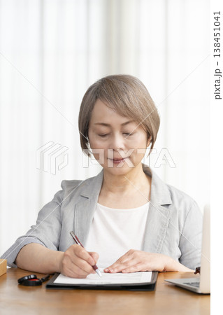 契約書に署名捺印するシニア女性 138451041
