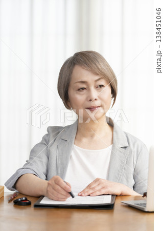 契約書に署名捺印するシニア女性 138451046