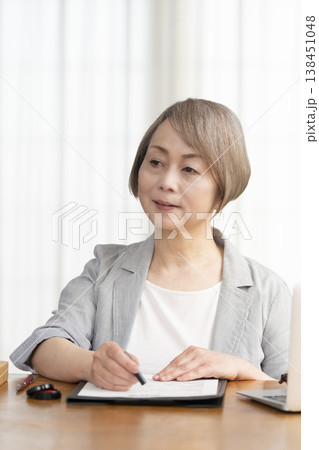 契約書に署名捺印するシニア女性 138451048