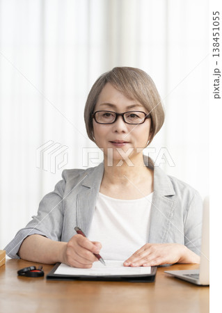 契約書に署名捺印するシニア女性 契約書に署名捺印するシニア女性 138451055