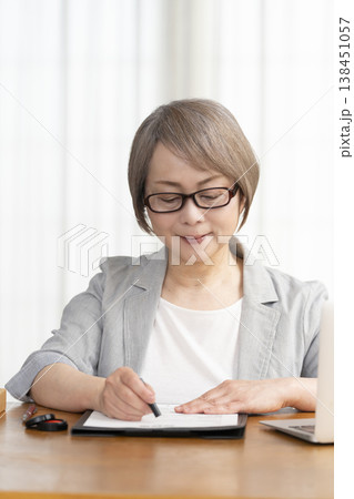 契約書に署名捺印するシニア女性 138451057