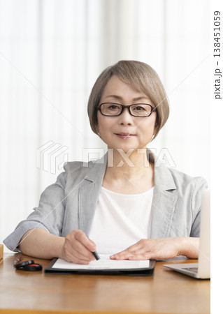 契約書に署名捺印するシニア女性 138451059