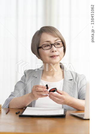 契約書に署名捺印するシニア女性 138451062