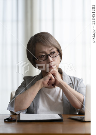 契約書に署名捺印を悩むシニア女性　ネガティブ 138451283