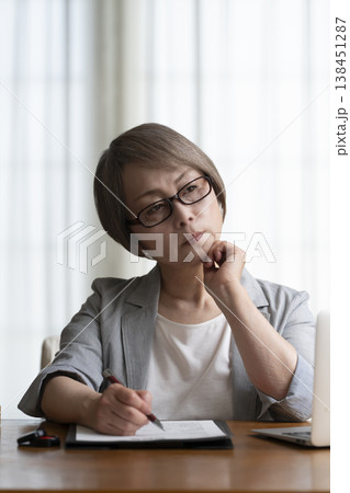 契約書に署名捺印を悩むシニア女性　ネガティブ 138451287
