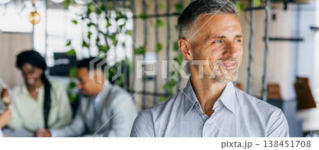Highranking professional analyzing plans with attentive colleagues nearby Highranking professional analyzing plans with attentive colleagues nearby 138451708