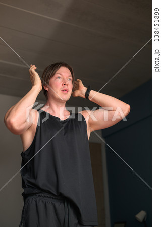 Caucasian Man in Black Tank Top Adjusting Hair in Minimalist Bedroom Caucasian Man in Black Tank Top Adjusting Hair in Minimalist Bedroom 138451899