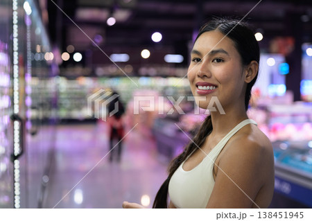 Smiling Asian Woman in Grocery Store Aisle with Copy Space and Shallow Depth of Field Smiling Asian Woman in Grocery Store Aisle with Copy Space and Shallow Depth of Field 138451945