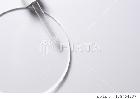 A glass circle on a white background. A template for placing samples of cosmetics or medical products or food. 138454237