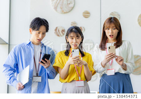 スマホを囲み驚く男女 138454371