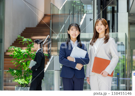 笑顔のスーツを着た若い男女 138455146