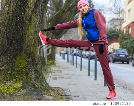 Woman wearing sportswear exercising outside during autumn 138455189