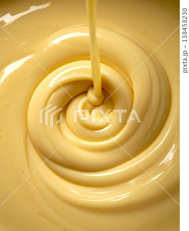 淡い黄色のクリームが渦を描くつや感テクスチャのクローズアップ 138458230