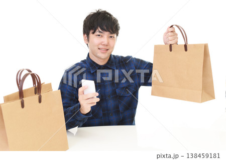 スマートフォンと買い物袋を持つ男性 スマートフォンと買い物袋を持つ男性 138459181