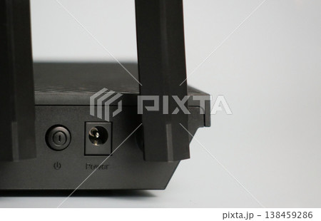 Close-up of a modern WiFi router with antennas and power port. Minimal tech concept for internet connection, networking, smart home, and digital communication Close-up of a modern WiFi router with antennas and power port. Minimal tech concept for internet connection, networking, smart home, and digital communication 138459286
