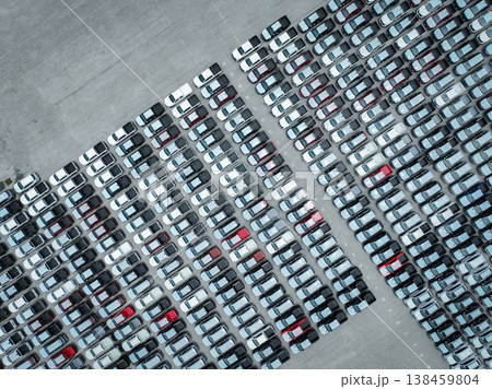 Aerial view of new cars stock at a large factory parking lot. Automotive industry, logistics operations, and vehicle storage for import and export. Key role in the global car market supply chain. 138459804