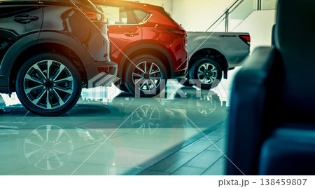 Luxury car parked in modern showroom. Auto leasing business. Car dealership concept. Closeup wheel of red shiny car show in showroom. Automotive industry. Auto glass coating and shinning business. 138459807