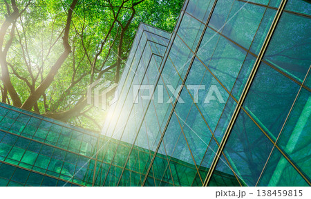 Sustainble green building. Eco-friendly building in modern city. Sustainable glass office building with tree for reducing carbon dioxide. Office with green environment. Corporate building reduce CO2. 138459815