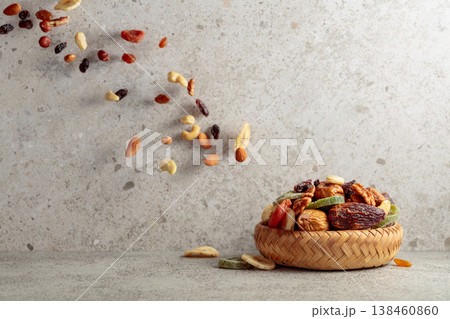 Mix of dried fruits and nuts in motion on a gray background. Mix of dried fruits and nuts in motion on a gray background. 138460860