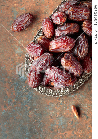Dried dates fruit in silver tray on a rustic background. Dried dates fruit in silver tray on a rustic background. 138460866