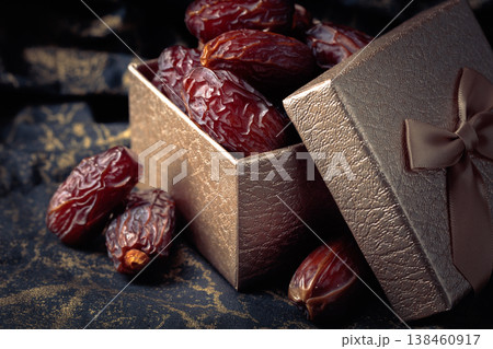 Dates in a gift box on black fabric with gold ornamentation. 138460917