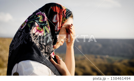 Muslim woman in floral hijab contemplating desert landscape Muslim woman in floral hijab contemplating desert landscape 138461494