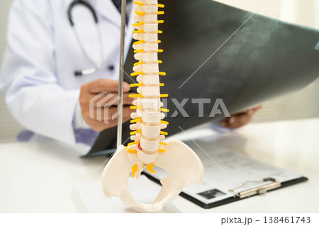 Doctor examining spine bone radiography xray film. Doctor examining spine bone radiography xray film. 138461743