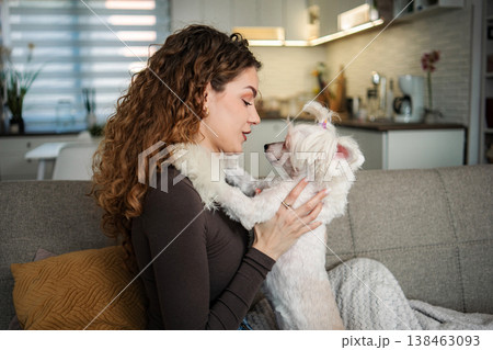 Young woman enjoying companionship with her small dog at home Young woman enjoying companionship with her small dog at home 138463093