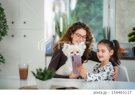 Mother daughter and pet dog taking selfie with smartphone 138463117